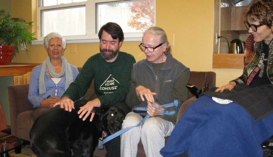 Neighbors, Co-Residents Sit On Sofa And Play With Dog, Co-Housing, Livable Communities