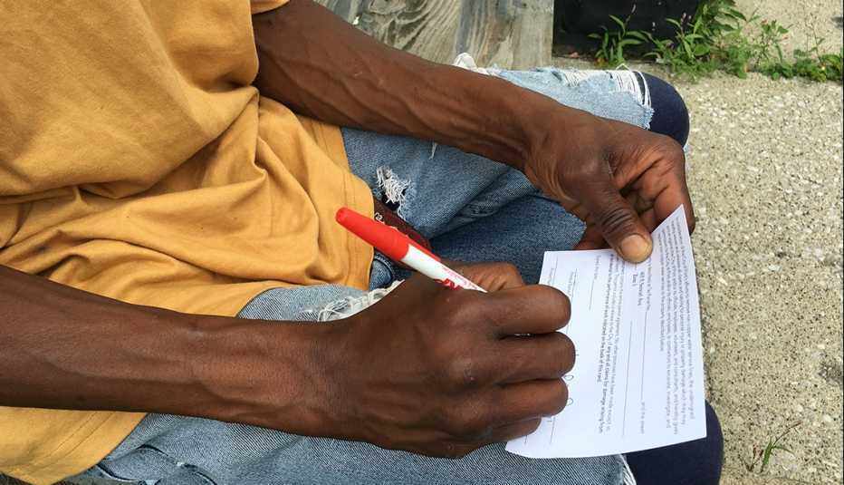 A resident of Flint, Michigan, completes a form allowing for the replacement of the main water pipe to his home. 