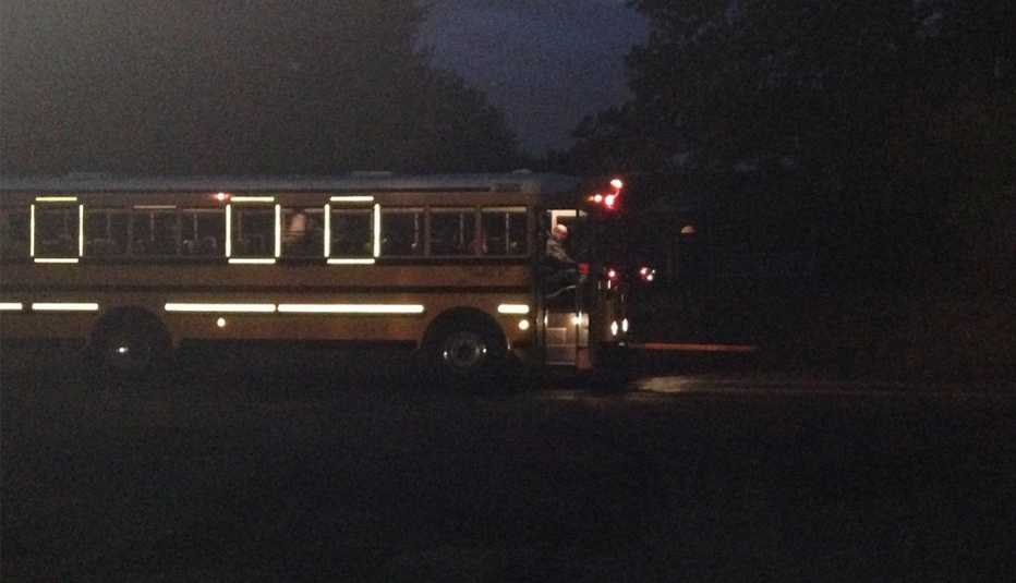 A high school-bound bus in Anne Arundel County, Maryland, picks up students in the 6:41 a.m. darkness of an October morning