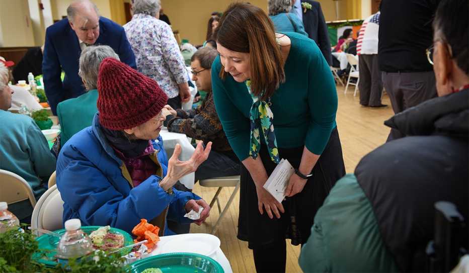 Emily Shea listens to a senior citizen at an event in Boston