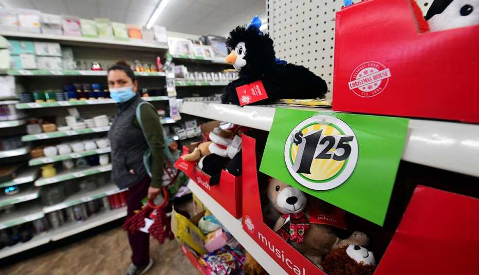 A shopper walks by a sign displaying $1.25 price, posted on the shelves of a Dollar Tree store in Alhambra, California.
