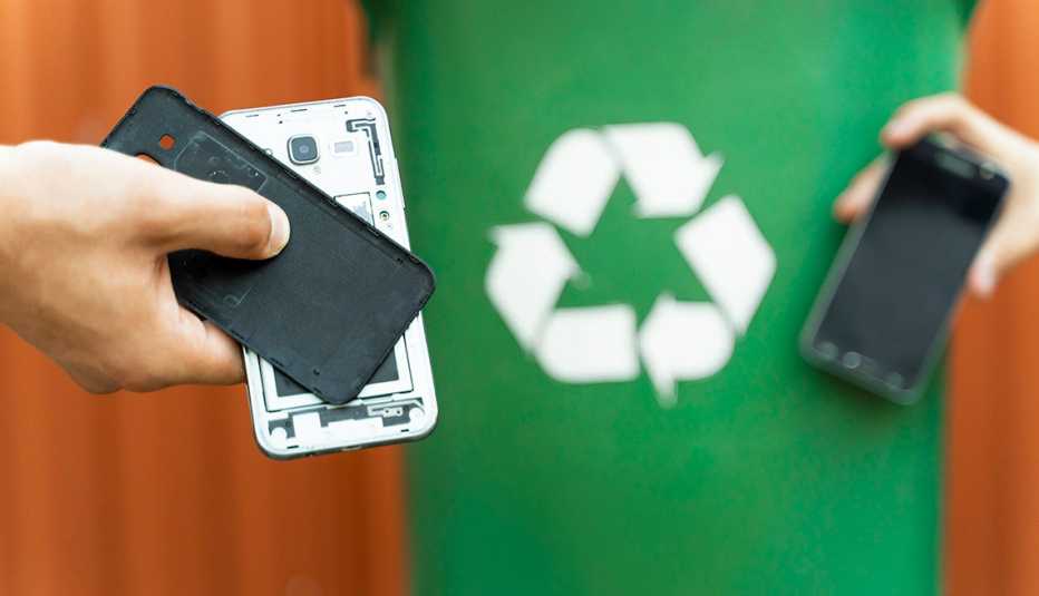 two smartphones in front of a recycling bin