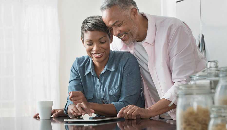 Couple using a tablet at a kitchen table