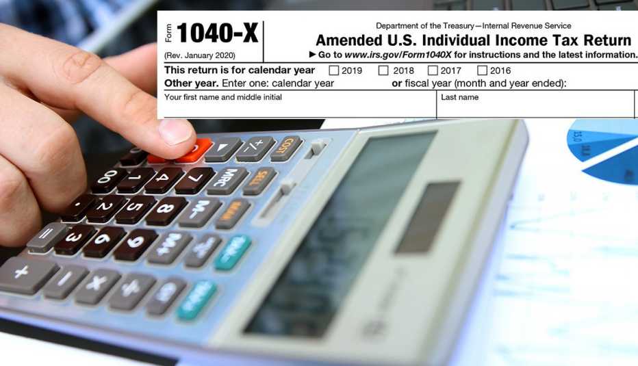 taxpayer with finger on calculator with part of the amended IRS tax form in view