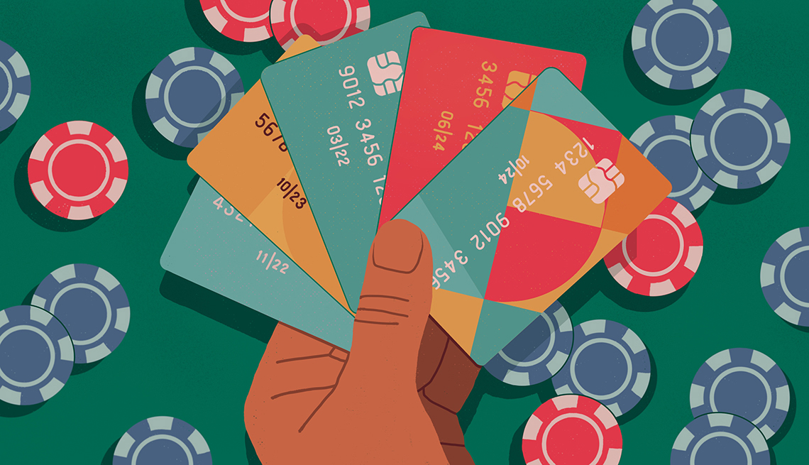 a hand holding a fan of credit cards overlaid on a poker table with chips in the background