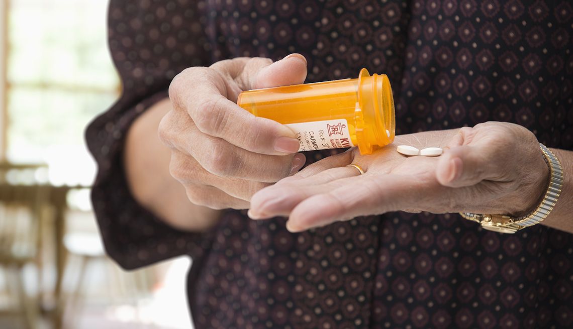 Mature women holding medication pills