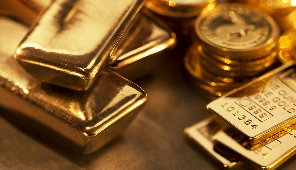 Close up image of assorted gold ingots and gold coins