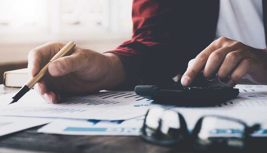 hands with calculator, pen and tax forms 