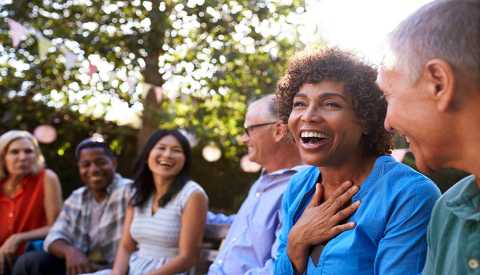 a group of six people laughing together outside