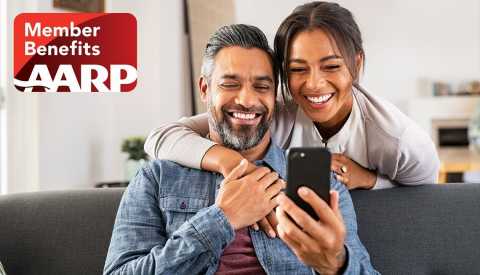 A A R P member benefits logo overlaying an image of a man and woman looking at a smart phone