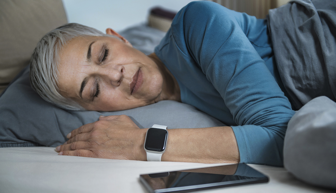 A woman is sleeping next to her smartphone