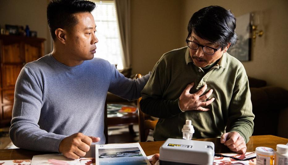 Son caregiving for his father with medical equipment