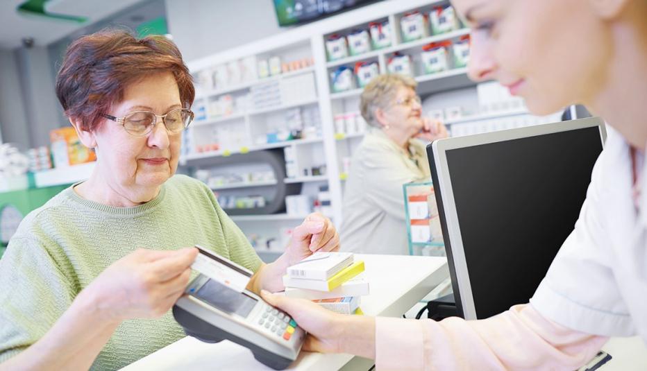 Senior customer paying by credit card at drug store