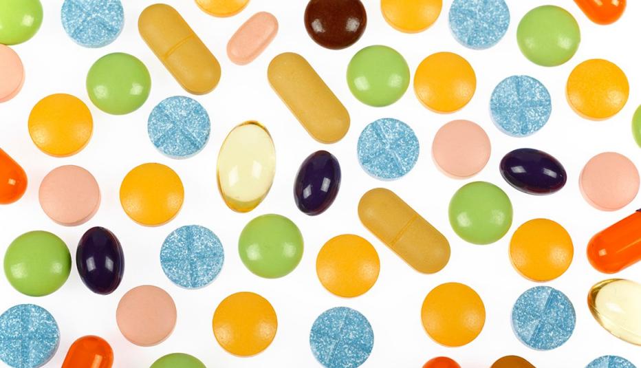 Various colorful pills and supplements on white background