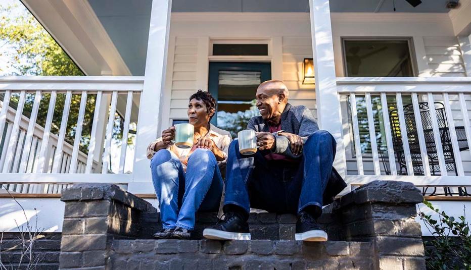 Older couple having coffee on front porch of their house