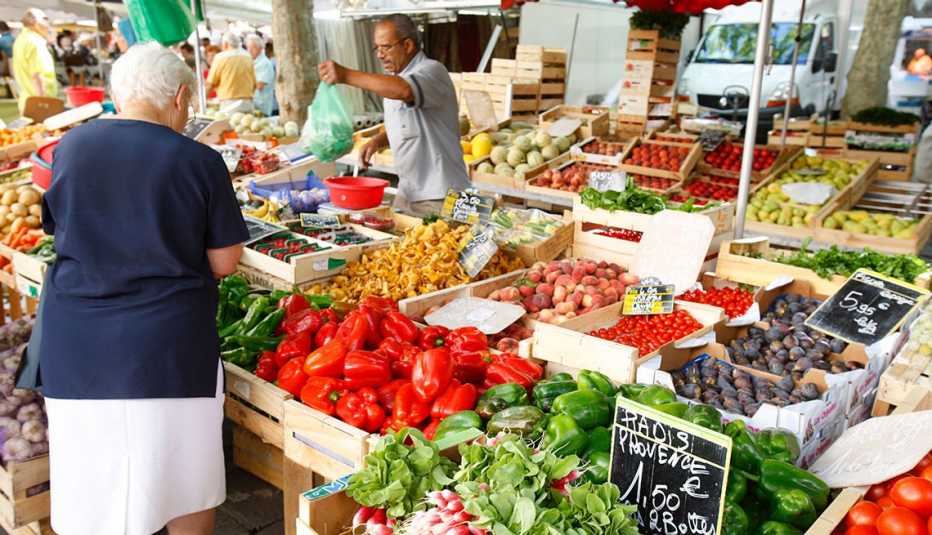 baskets of brightly colored vegetables at an open market in uzes france