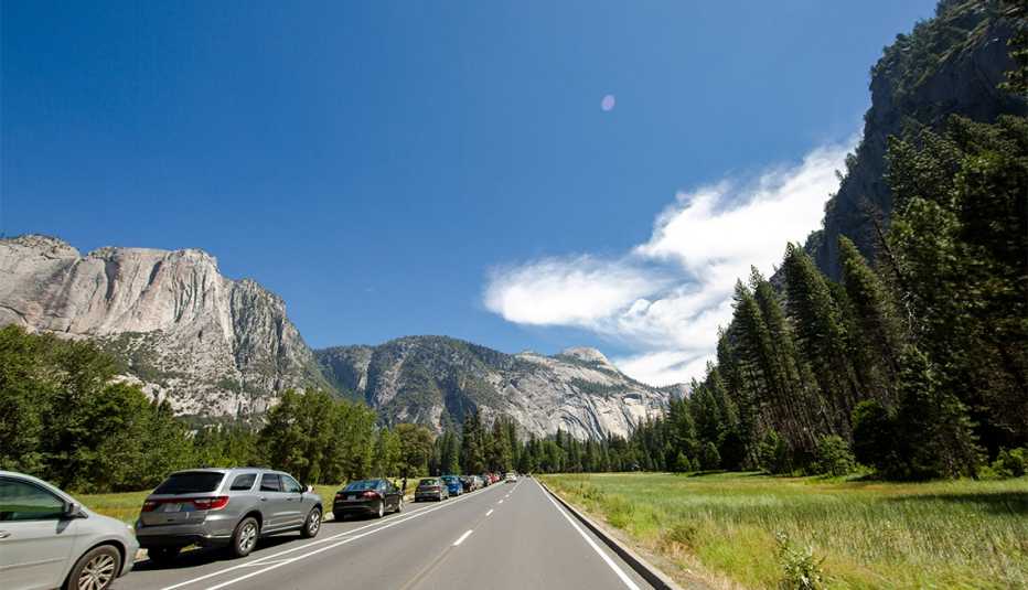 a line of cars drive toward Yosemite National Park entrance