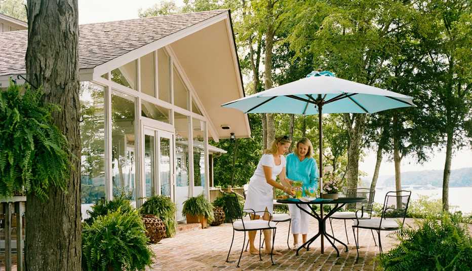 two women pour drinks on a desk patio