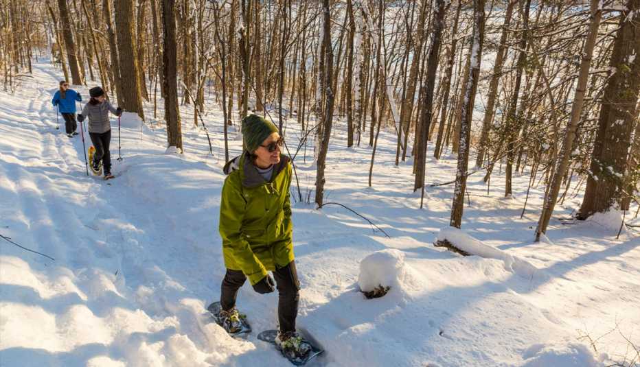 people snow shoeing in a snowy forest