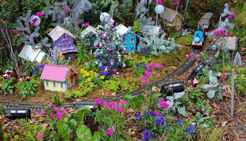 model trains travel through a colorful festive village