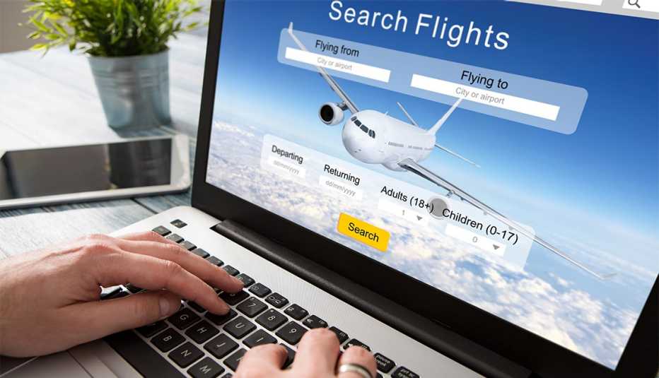 someone using a laptop to book a flight online