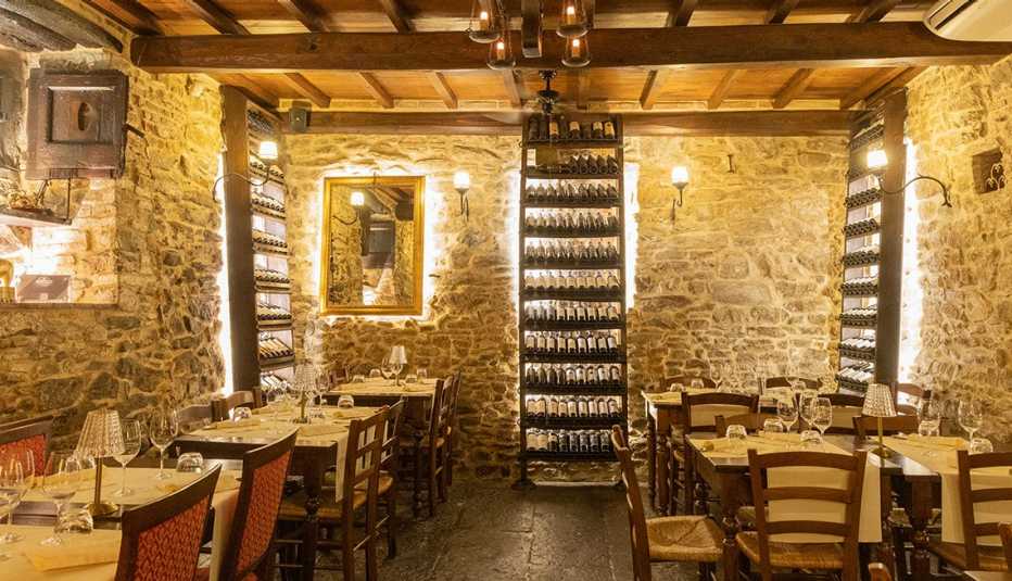 inside of restaurant showing wine racks and tables and chairs; wine glasses and place settings on table