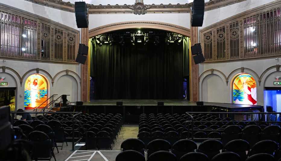 stage, rows of seats, stained glass windows in theater