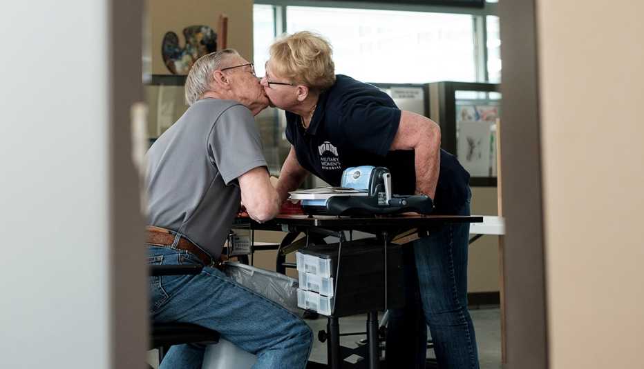 larry condon and his wife carol rhan kissing in a craft room