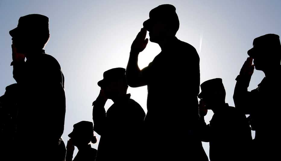 Several soldiers salute the flag