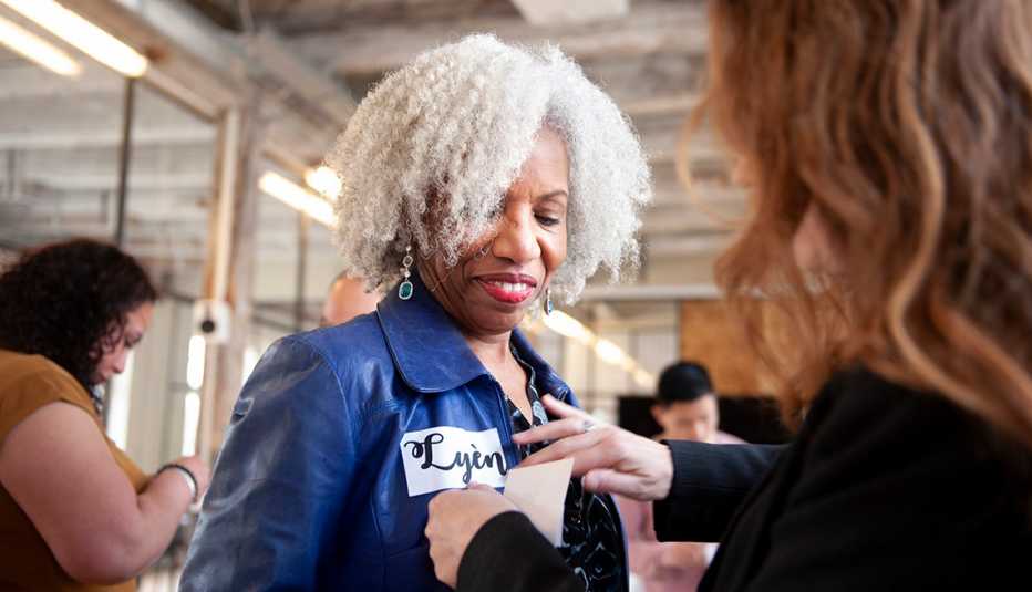 an employee in a blue jacket receives a new name tag