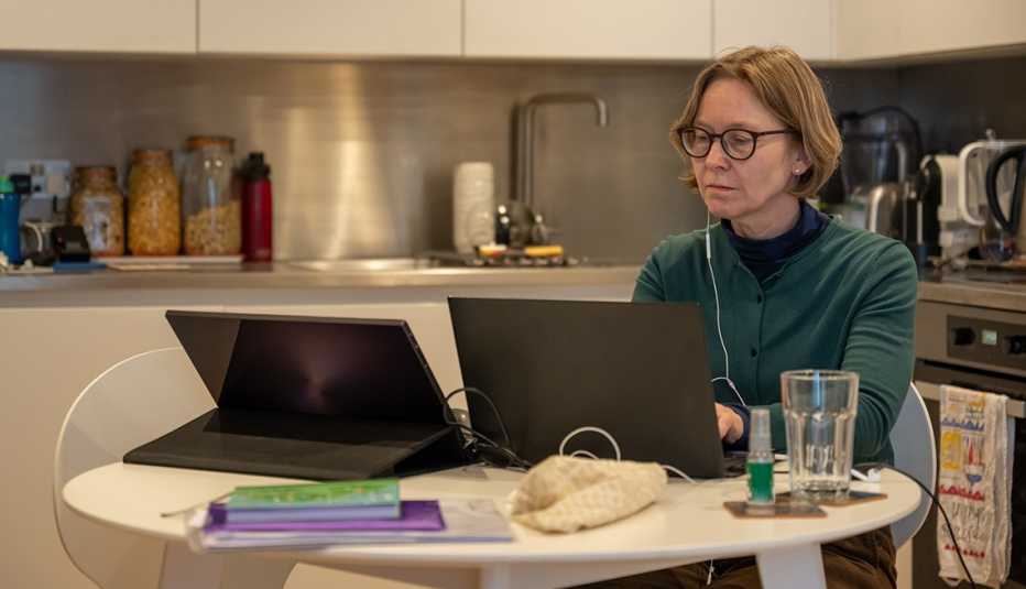 An older woman working from her kitchen table