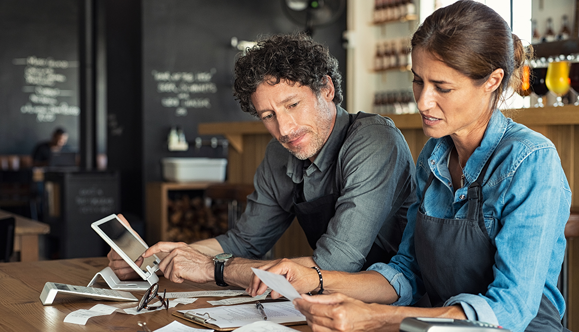 A man and a woman go through financial documents at a table