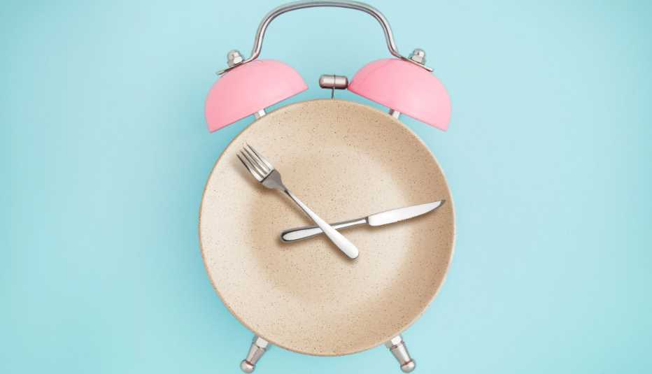 Reloj alarma y la parte redonda es un plato, cubiertos son las manecillas