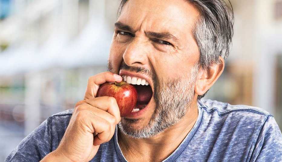 Hombre a punto de darle un mordisco a una manzana