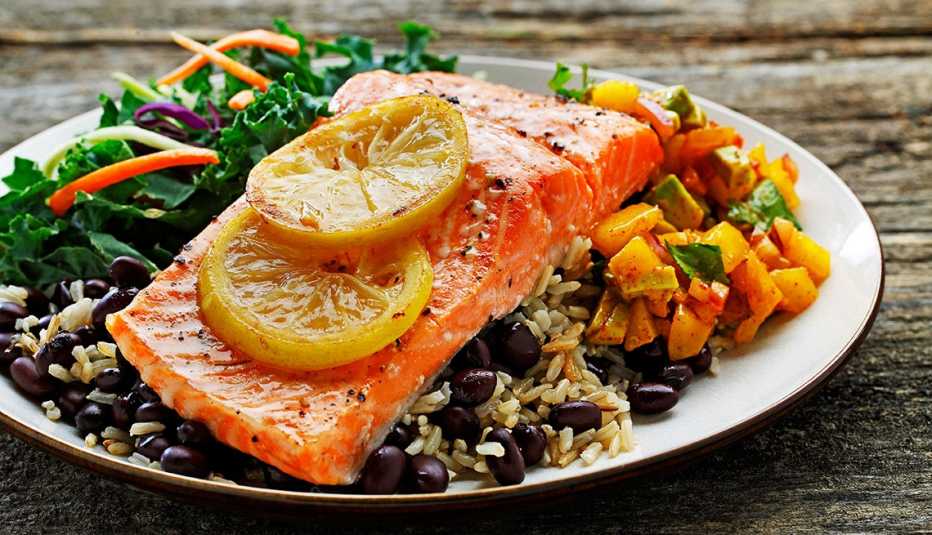 Plato de pescado con vegetales, arroz y frijoles