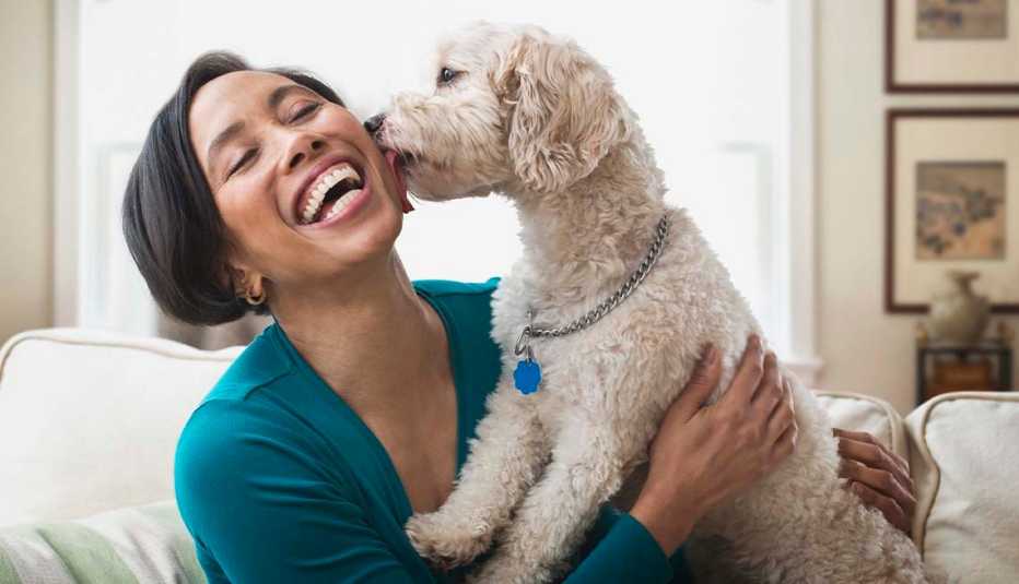 Una mujer se sienta en un sofá con su perro