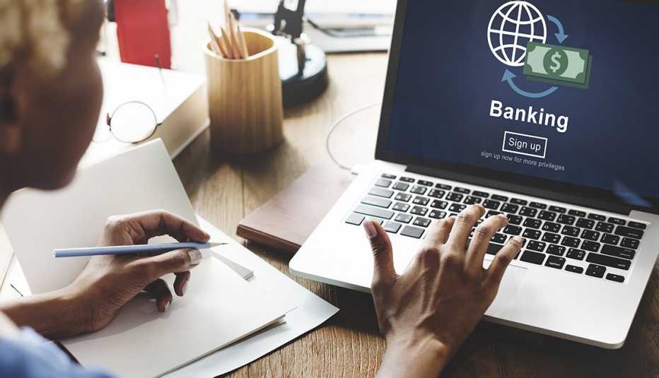 Mujer mirando la pantalla de una computadora con servicios bancarios.
