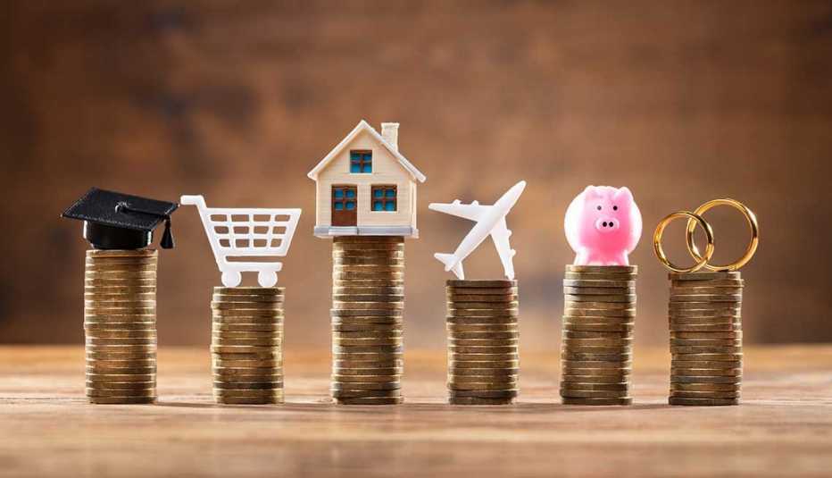 6 columnas de monedas apiladas y encima un birrete, un carrito de compras, una casa, un avión, una alcancía, y unos anillos