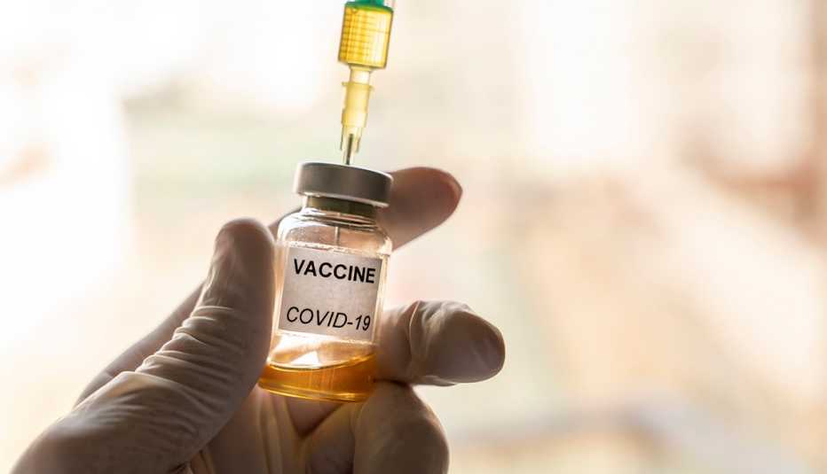 Persona sosteniendo una vacuna del coronavirus