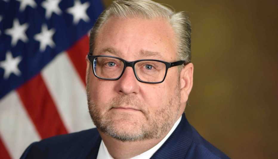 Fiscal general auxiliar, Brian Benczkowski, al lado de la bandera de Estados Unidos.