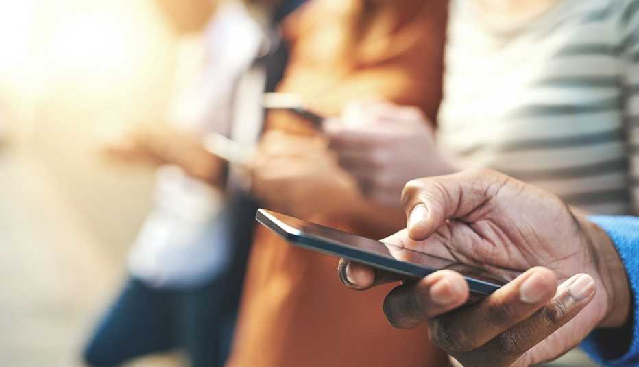 Personas viendo el teléfono móvil.