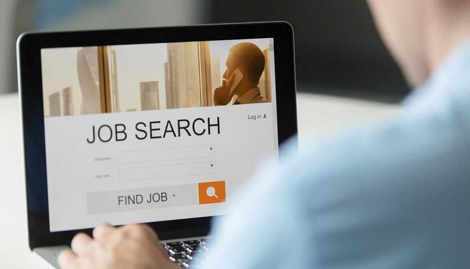 Hombre buscando trabajo en una computadora.