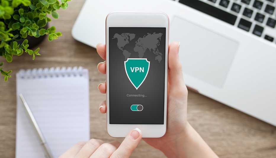 Mujer sostiene un teléfono inteligente que muestra una aplicación de VPN