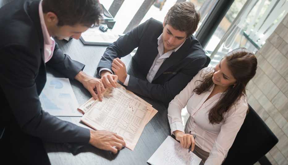 Hombre revisando un contrato con una pareja - Errores frecuentes al comprar un negocio