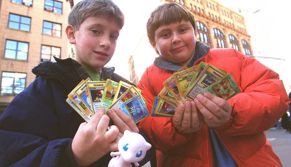 Dos niños con tarjetas de Pokemón  en la mano.
