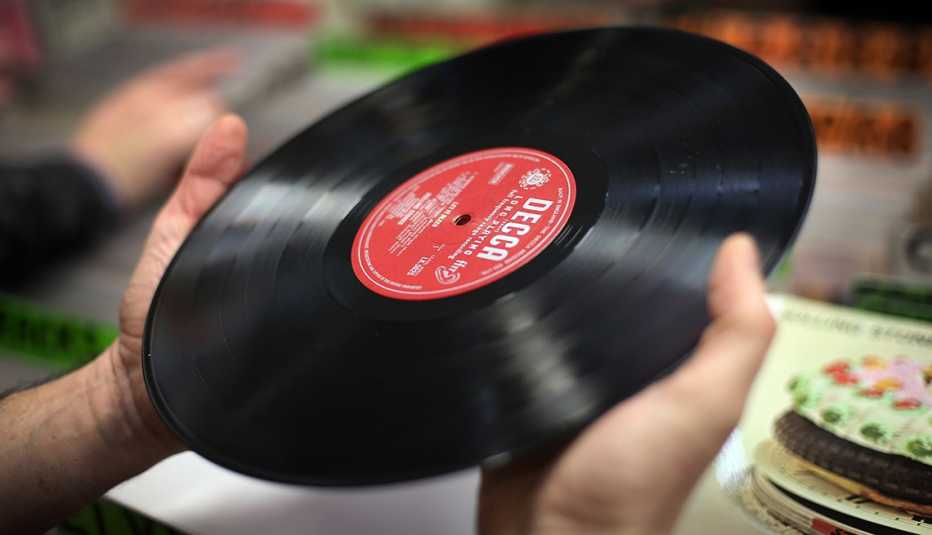 Manos sostienen un disco de acetato.