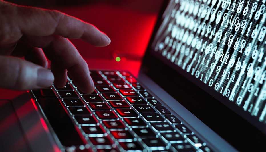 Computadora portátil corriendo un programa malicioso  mientras alguien digita.