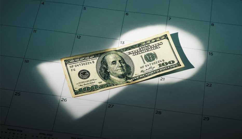Billete de 100 dólares sobre hoja de calendario mensual