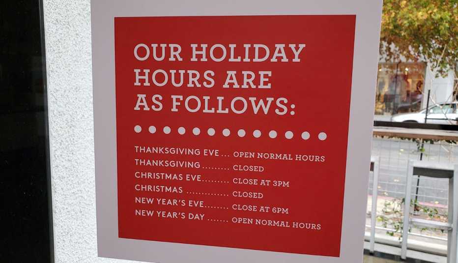 Vitrina de una tienda que anuncia los horarios durante la temporada de fin de año