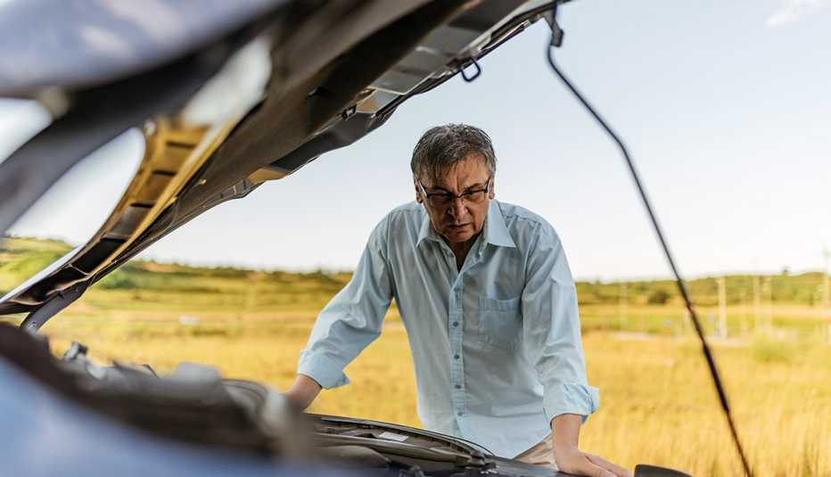 Hombre observa el motor de su auto